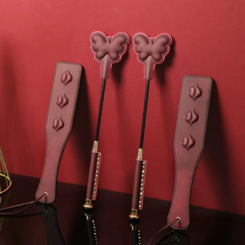 ALT: Cute paw print leather spanking paddle in white, black, and purple